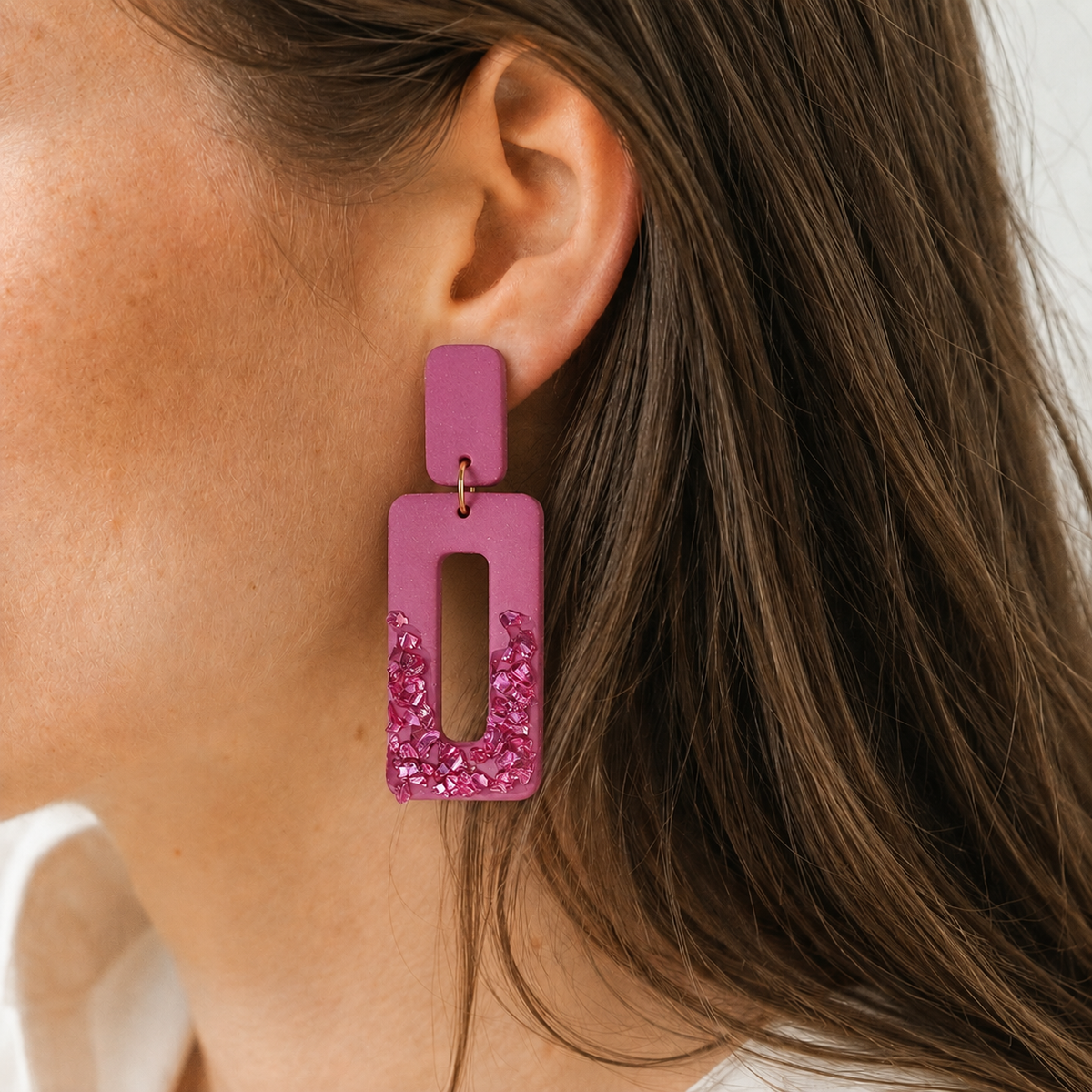 Paarse oorbel in oor afgewerkt met crushed glass roze