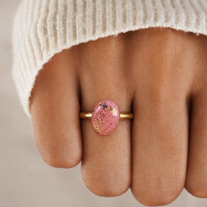 Ring met roze cirkelvormige polymeerkleivorm, afgewerkt met schilfers goudblad en resin 