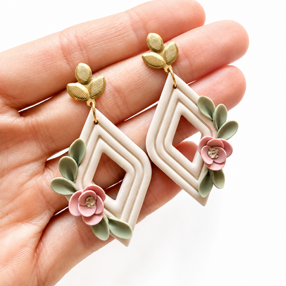 Isabelle cutter, ruitvormige polymeerklei oorbellen met bloemen op hand