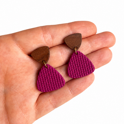Jasmijn cutter, paarse polymeerklei oorbellen met houten oorstekers op hand