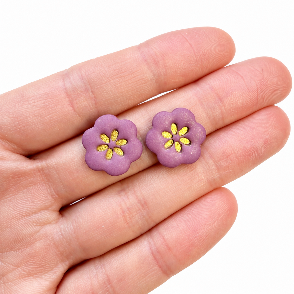 Paarse bloemen oorbellen op hand, gemaakt met de Leonie cutter