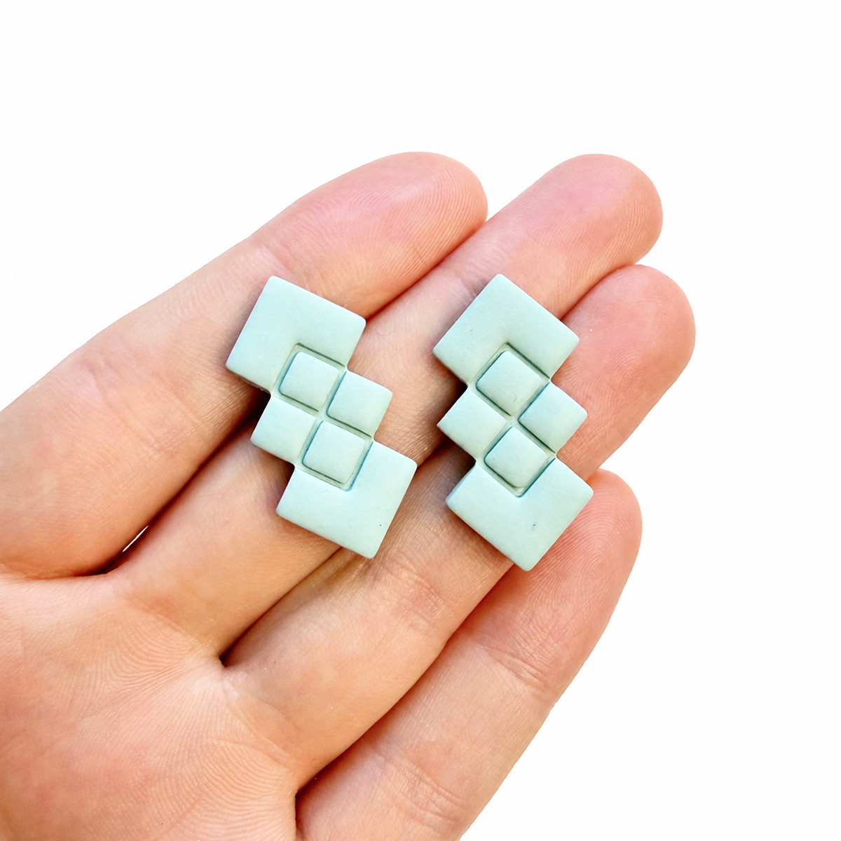 Strakke geometrische polymeerklei oorbellen gemaakt met de Lucille cutter, op hand