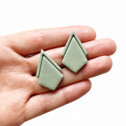 Groene polymeerklei oorbellen op hand, gemaakt met de Noali cutter