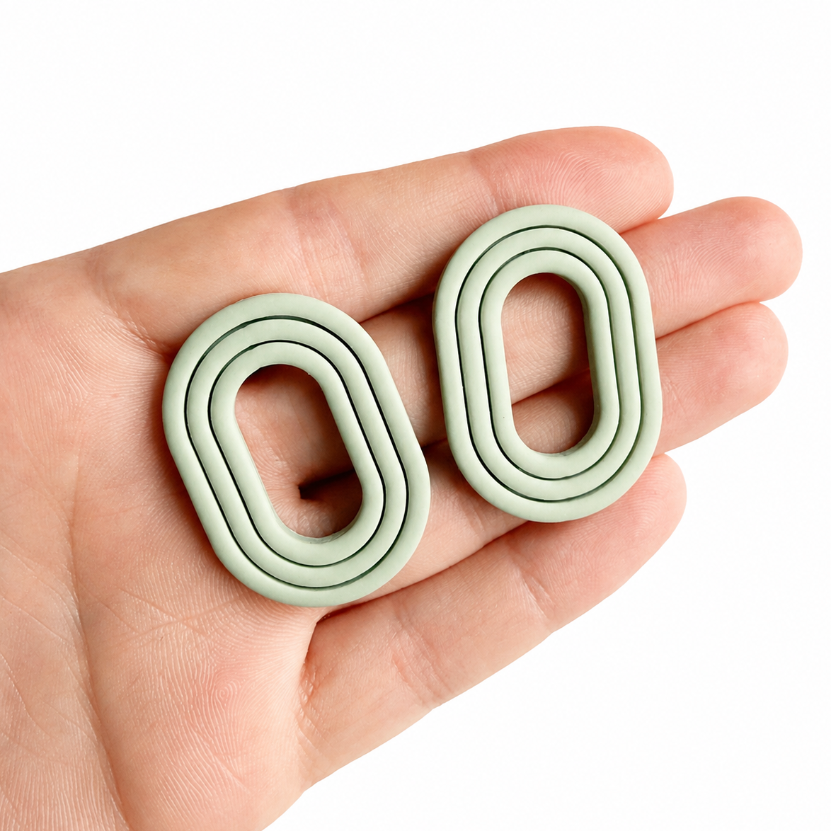 groene polymeerklei oorbellen op hand, gemaakt met Noemie cutter groot