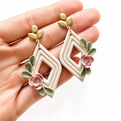 Ruitvormige polymeerklei oorbellen met bloemen, afgewerkt met oorstekers blad goud op hand