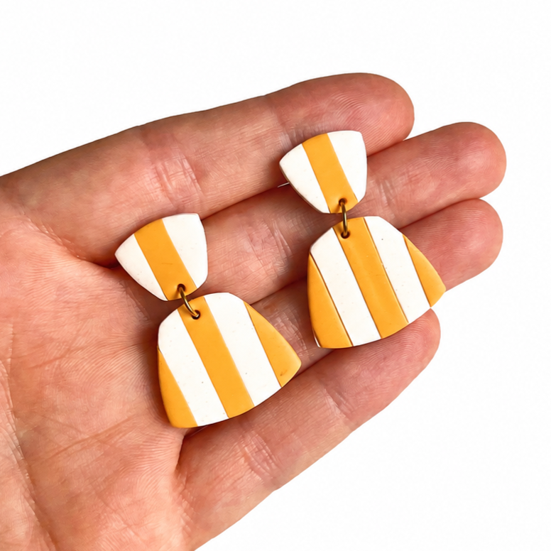gestreepte polymeerklei oorbellen op hand, gemaakt met de Romy cuter