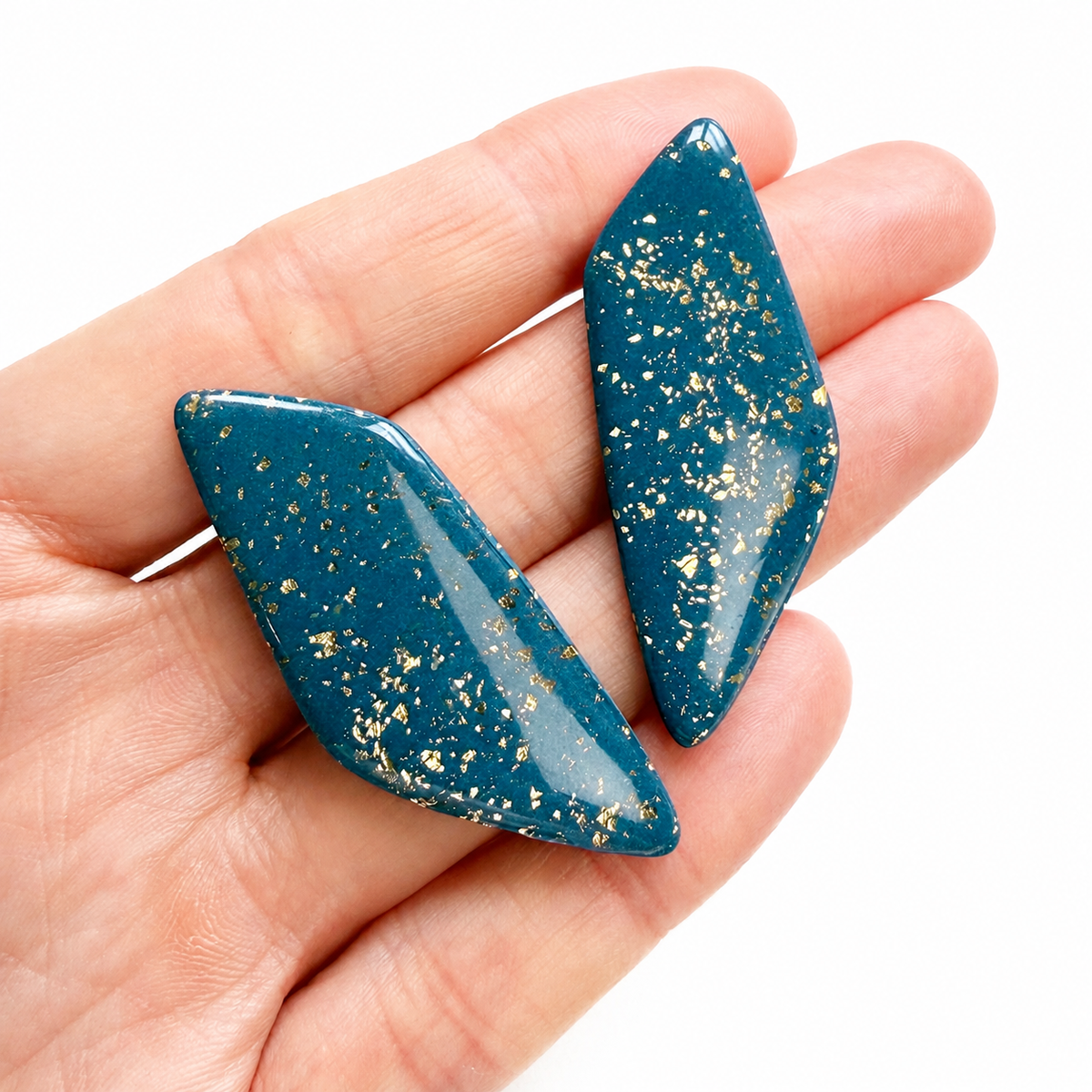 Roxy cutter, blauw met gouden polymeerklei oorbellen op hand