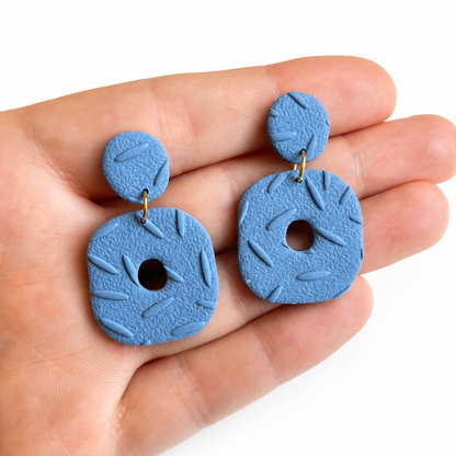 Sienna cutter, blauwe organische polymeerklei oorbellen op hand