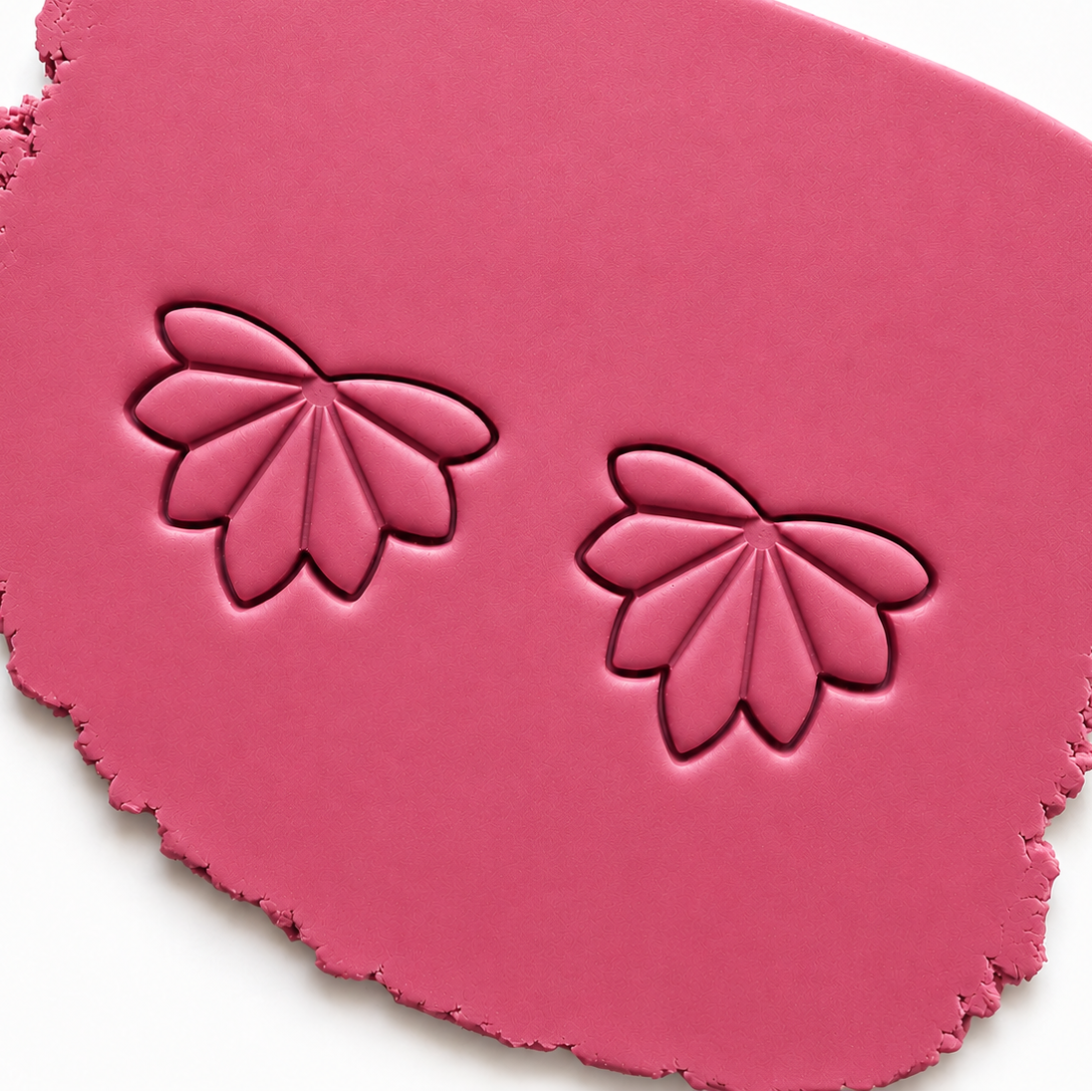 Afdruk van oorbellen in roze polymeerklei