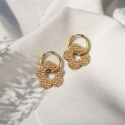 Beige bloemenoorbellen met bloemenreliëf gemaakt met structuurroller bloemen
