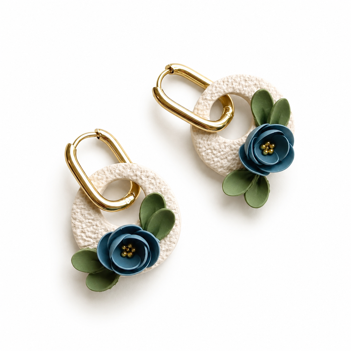 Beige polymeerklei oorbellen met schuurpapier structuur versiert met blauwe bloemen
