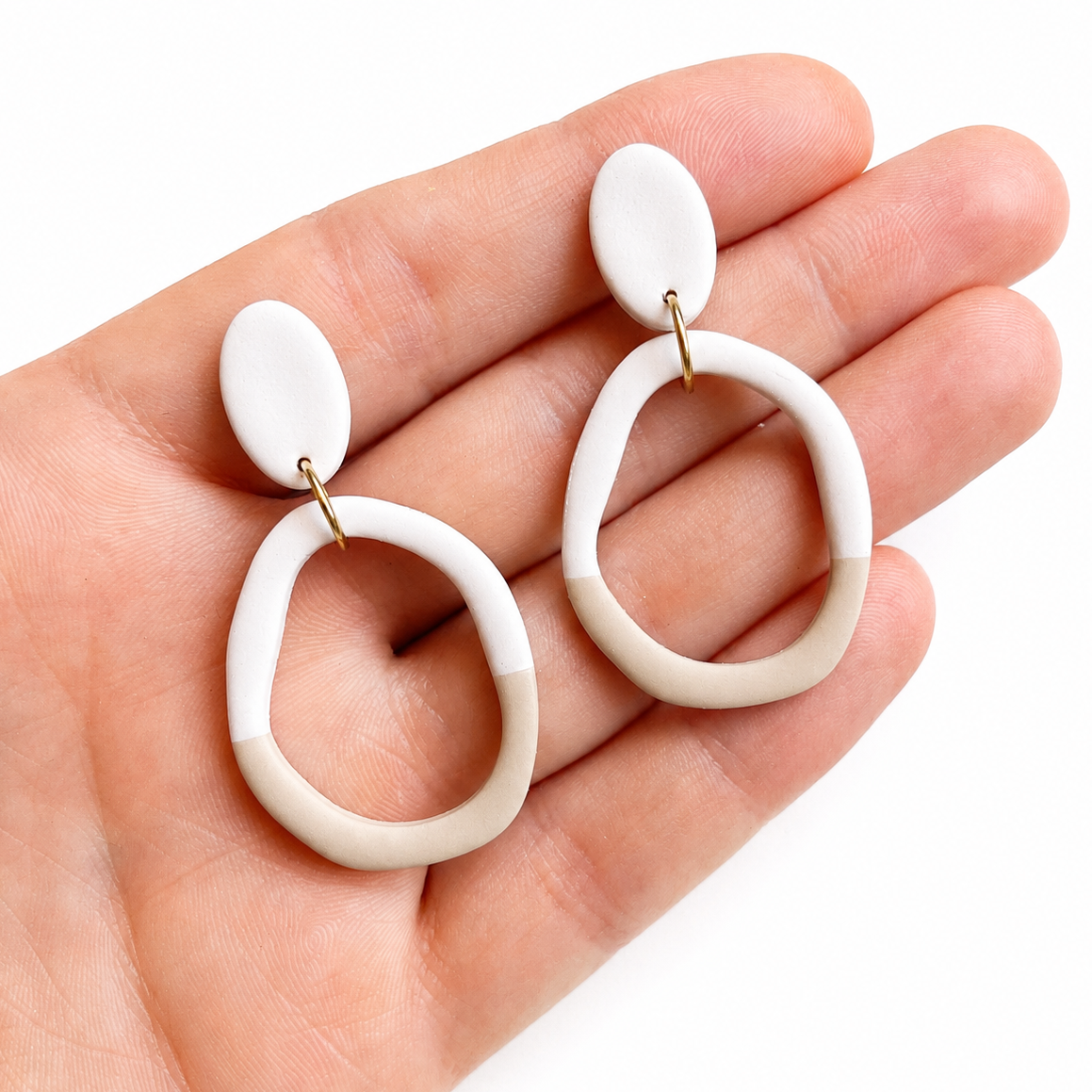 Sybil cutter, beige organische polymeerklei oorbellen op hand