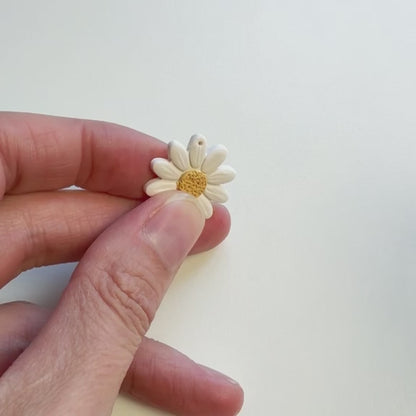 Gaatjes maken in polymeerkleioorbellen met een handboortje.